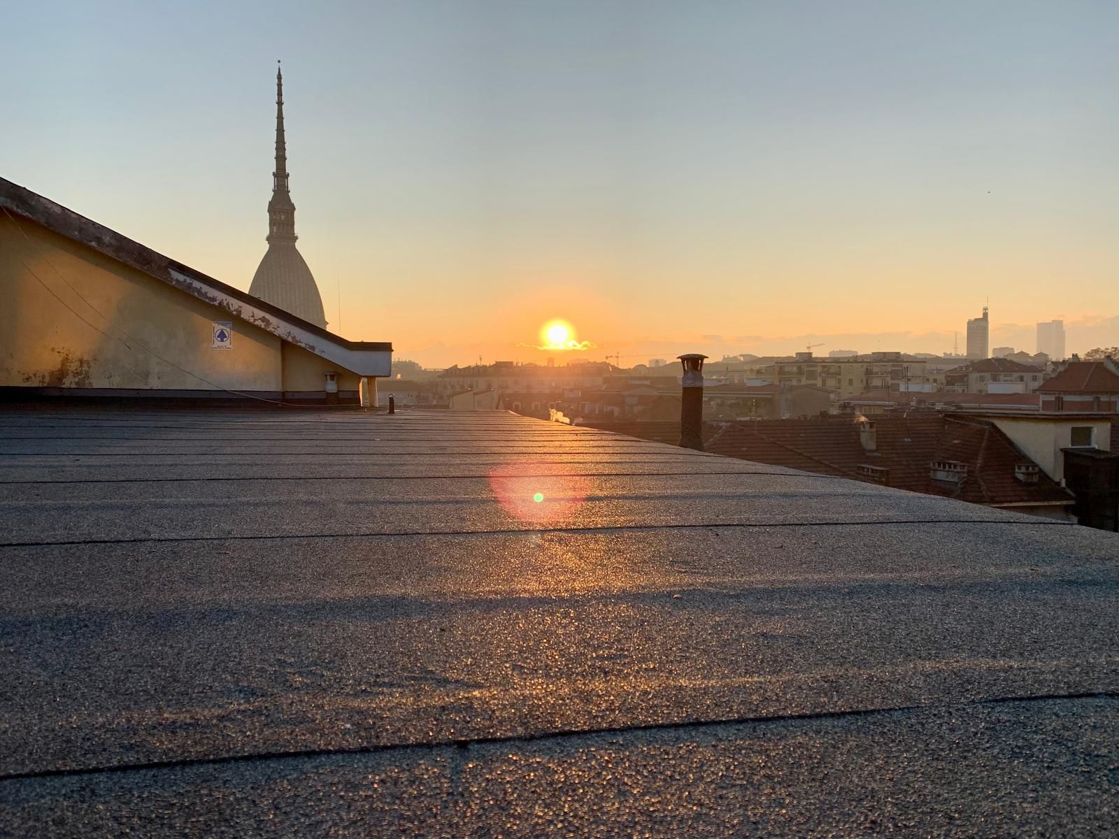 Copertura piana impermeabilizzata con vista sulla città al tramonto