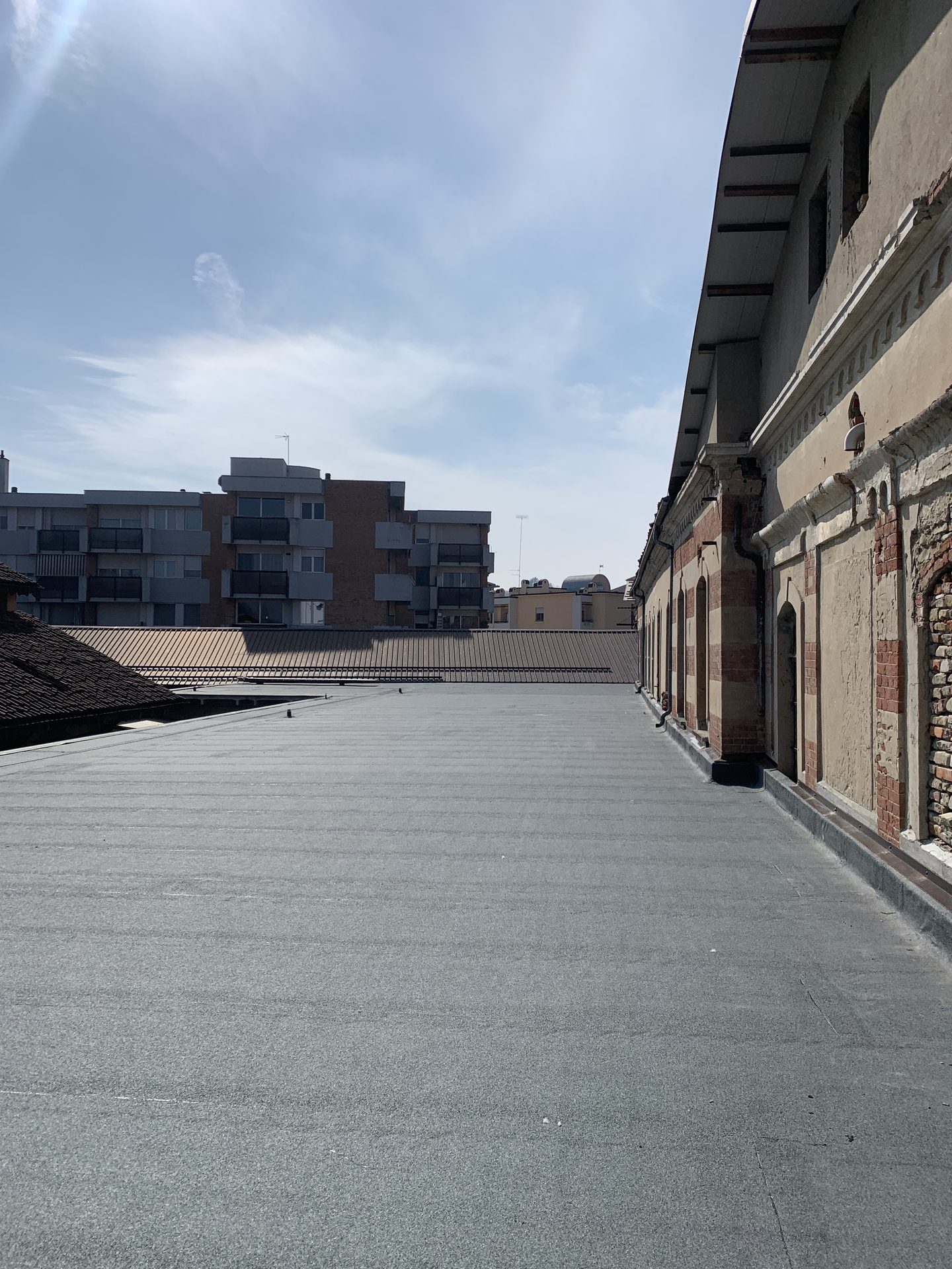 Copertura piana impermeabilizzata accanto a un edificio storico